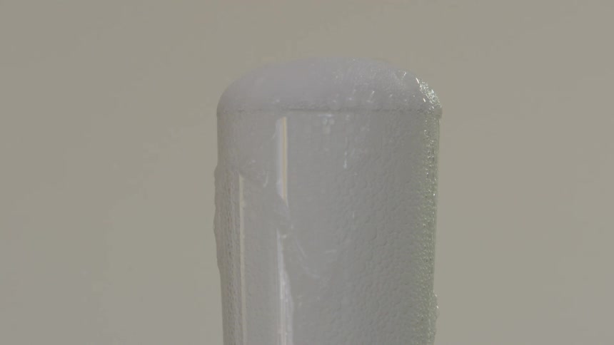 A glass overflowing from a carbonated beverage