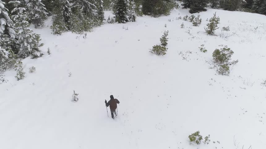 Man hiking on a snow covered hill during winter