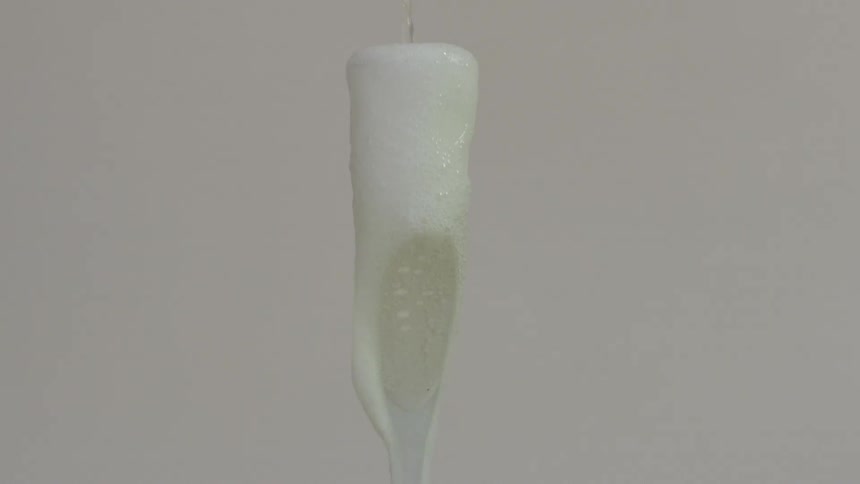 A champagne glass filling up with champagne