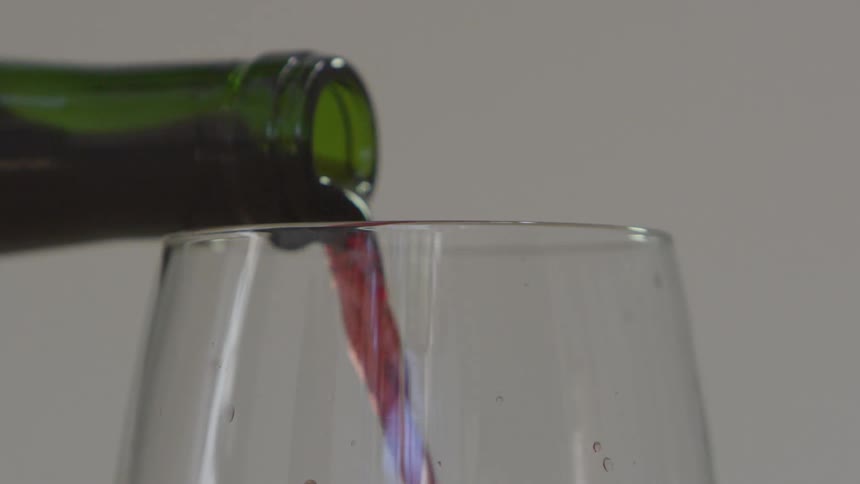 Red wine being poured from a bottle into a glass