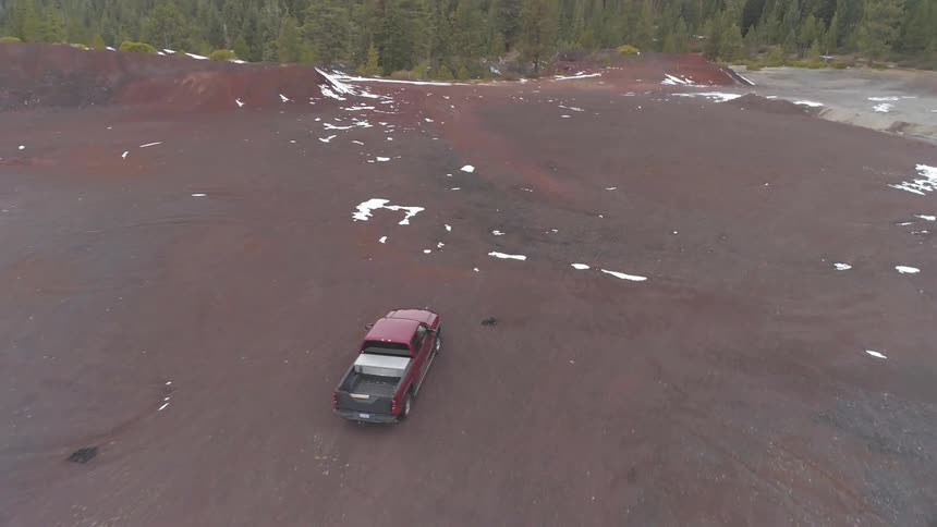 A truck driving through a large dirt area
