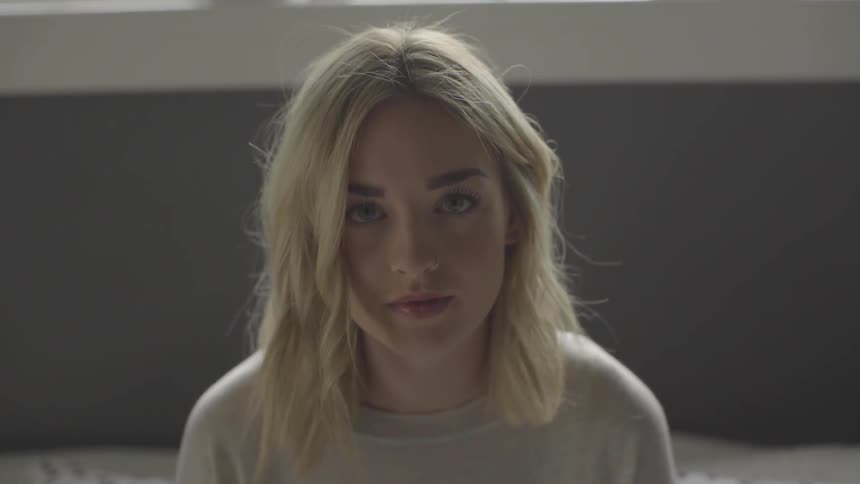 Blonde woman raises her head and stares ahead