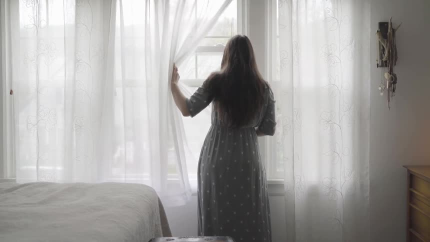 A woman is looking out a window