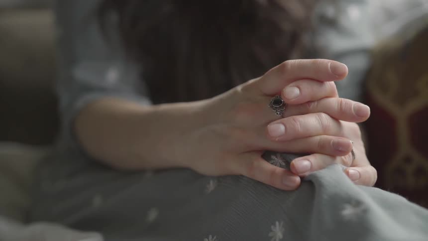 A woman is sitting on a bed indoors