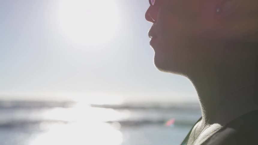 A person is standing outside by the beach