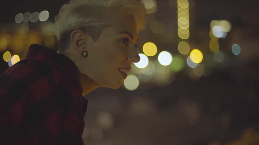 Woman with short blonde hair smiles and looks down