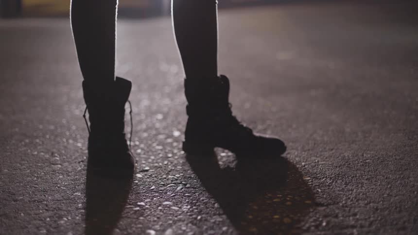 A person wearing books shifting positions on asphalt
