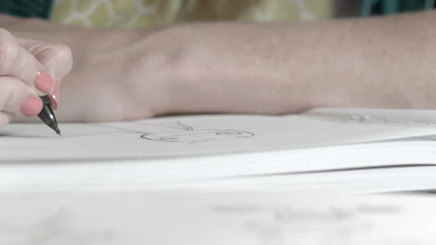 A person is writing on some paper in a lit room
