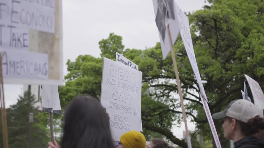 Protesters hold up signs