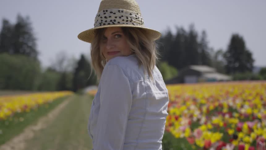 Woman walking through a tulip field