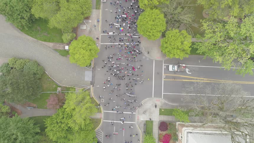 A large procession of people crossing an intersection