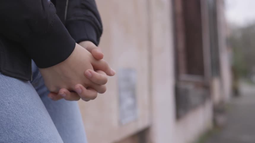 Woman clasps hands together