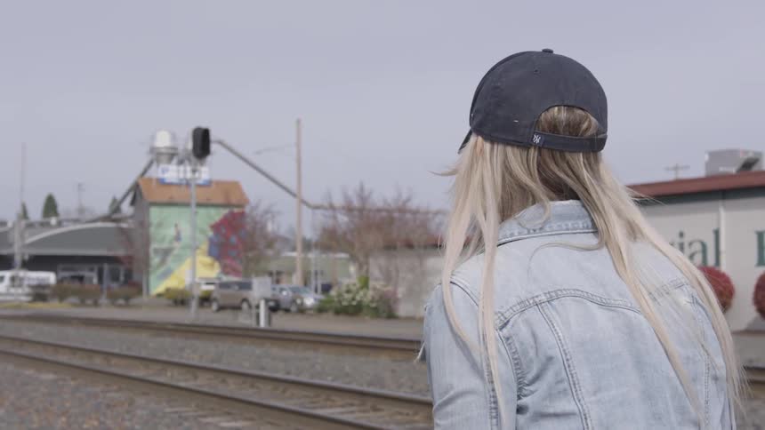 Woman walking next to railroad tracks
