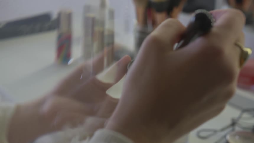 The hand is evenly distributing no make up on the make up brush