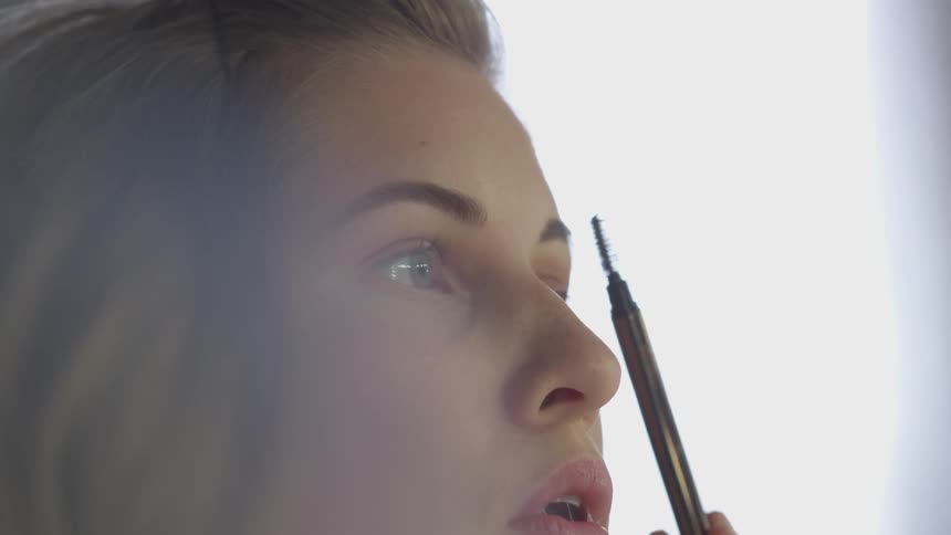 A woman is putting makeup on