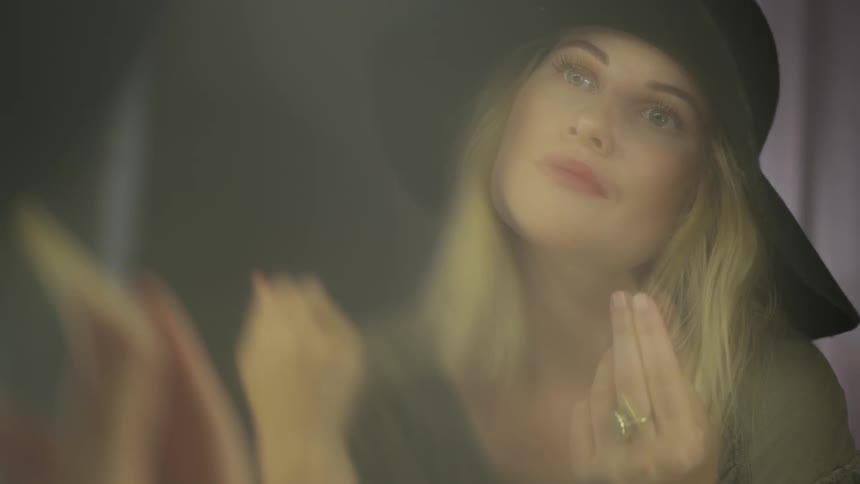 A woman playing with her hair in a mirror