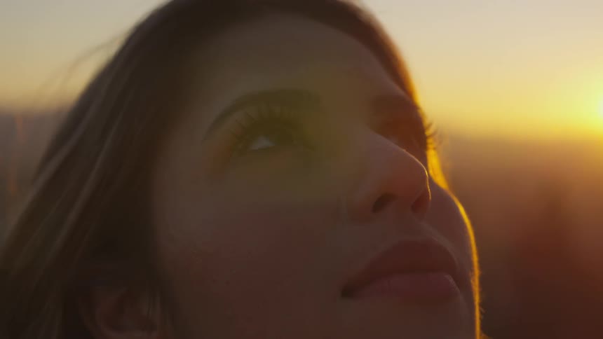 A young woman stares up at the sky