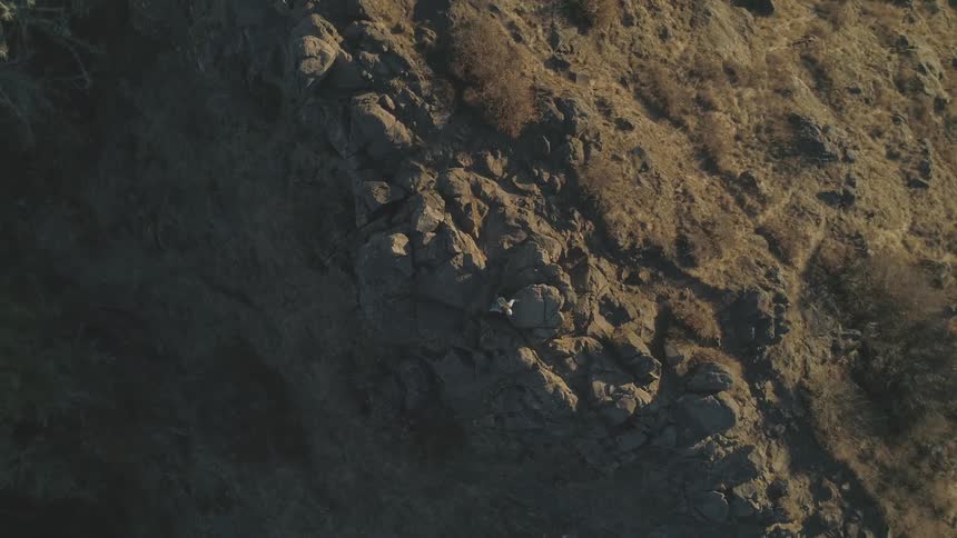 A person walking on top of a rock