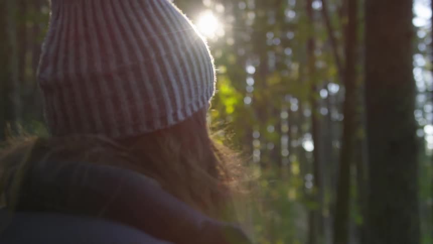 A lady is standing in the forest