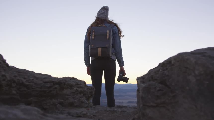 A female photographer looking over the landscape from a mountain top