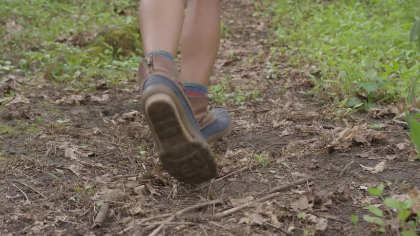 Someone walks through a dirt path