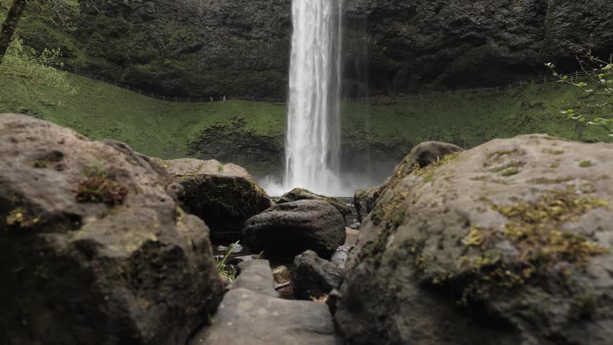 Water falls and lands in the rock filled water