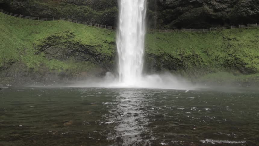 Water falls from a cliff down into a pool