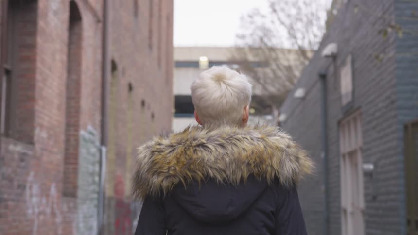 Person walks down an alley in a city