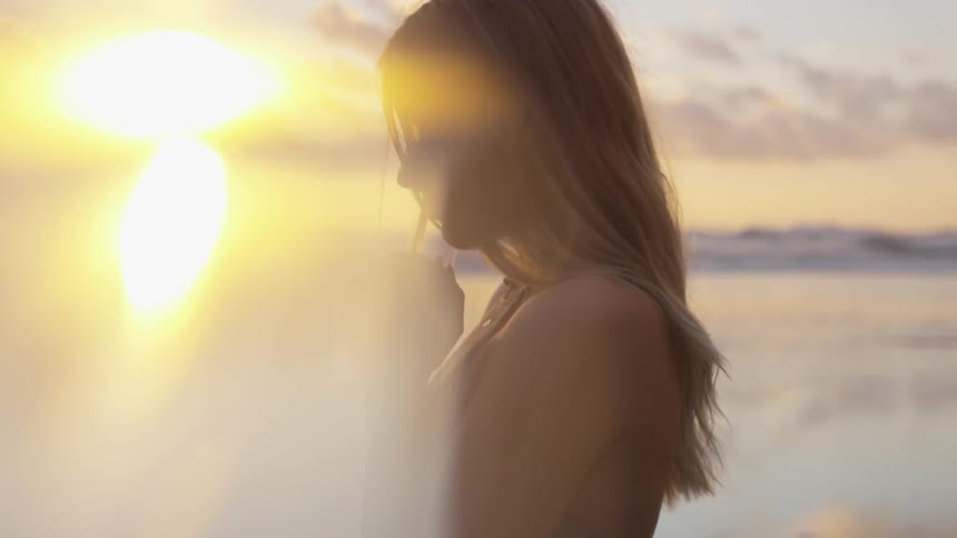 Blonde woman looks ahead and thinks when the sun goes down outdoors