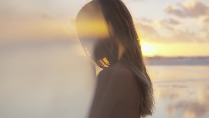 Woman stands in front of the sunset