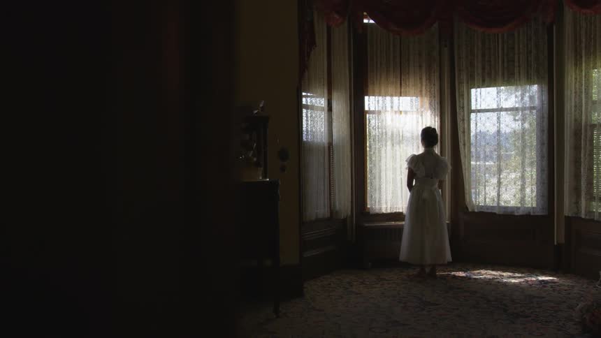 Girl standing in room with a white dress on