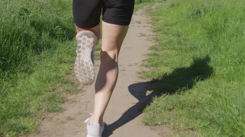 A person running on a dirt pathway at daytime