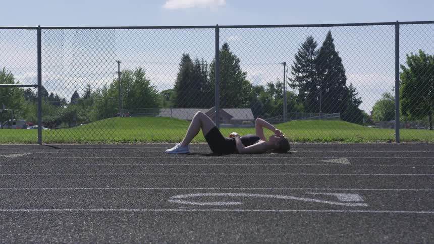 A runner lays on a track looking exhausted