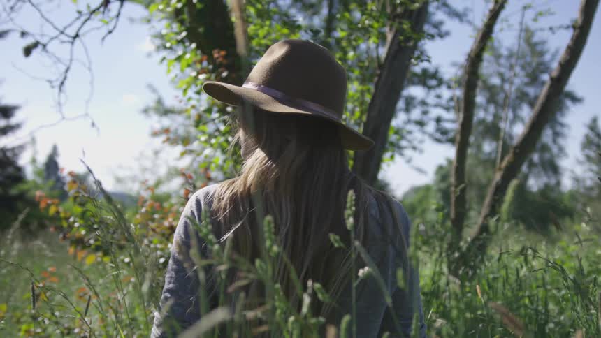 A woman standing in an overgrown field