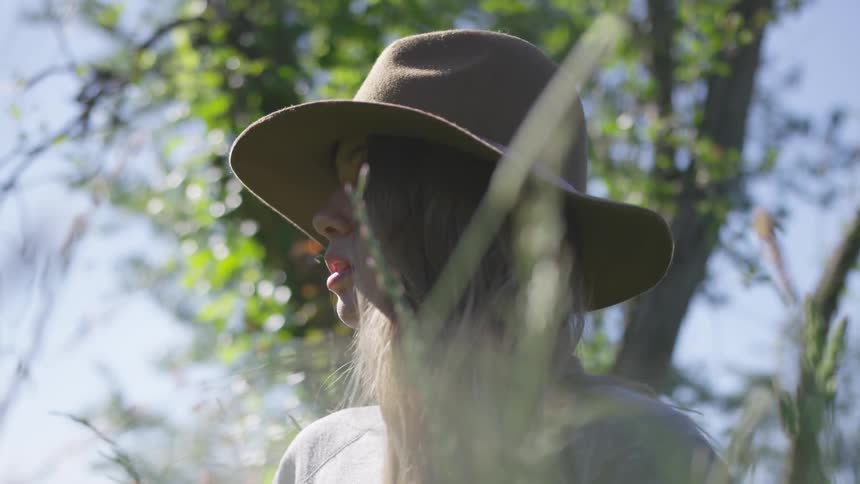 Woman sits in grass looking into the distance