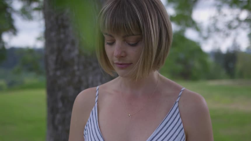 Woman stands under a tree