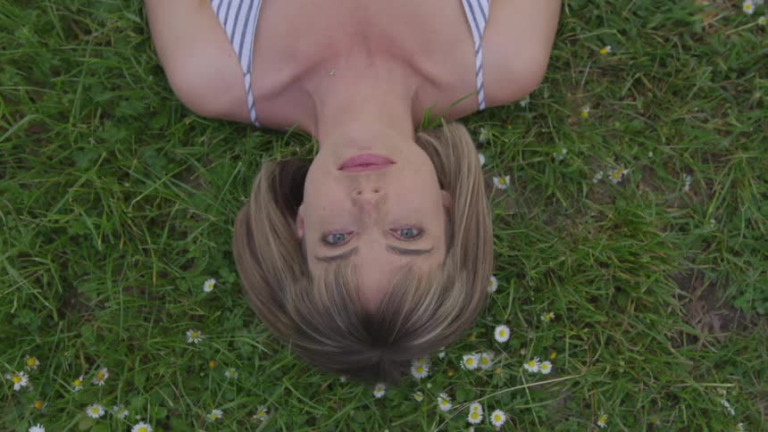 Woman laying on the grass looking at the camera