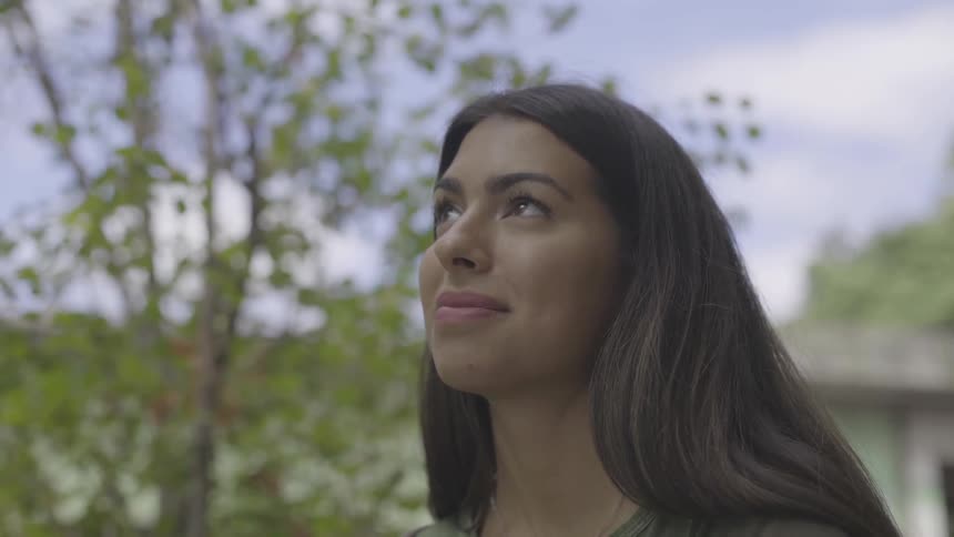 Woman standing outside looking at the sky on a clear day