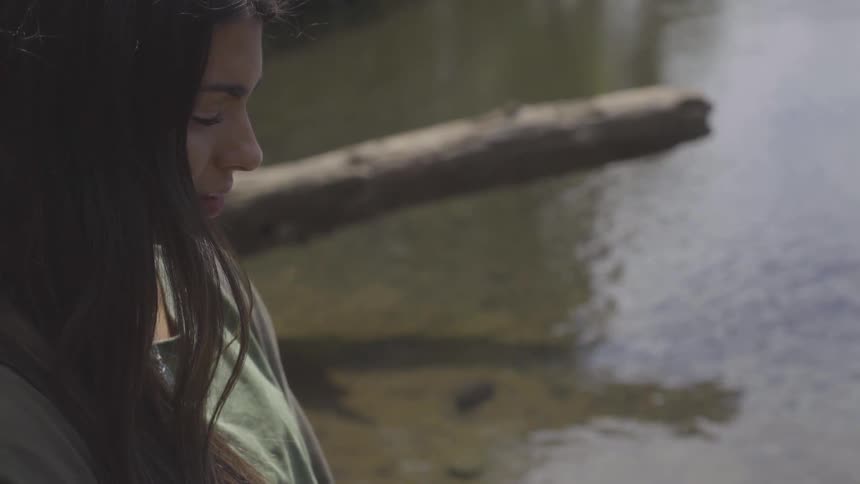 Woman stands near river