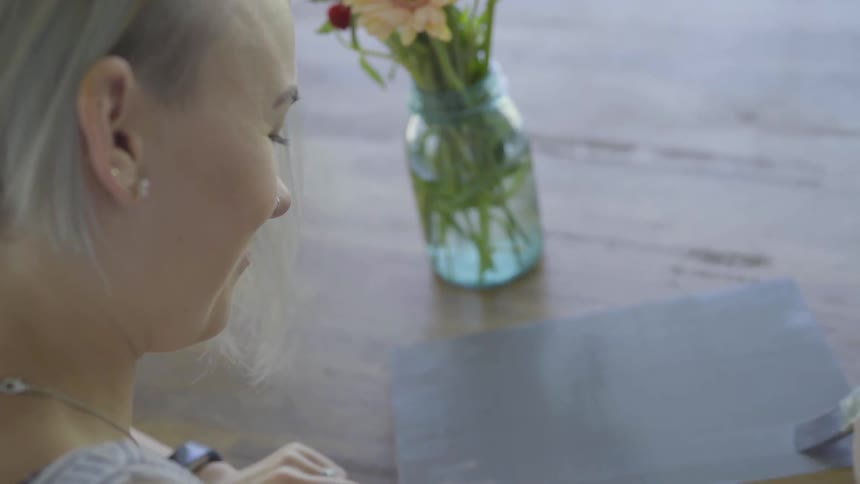 Woman paints on canvas laying on table