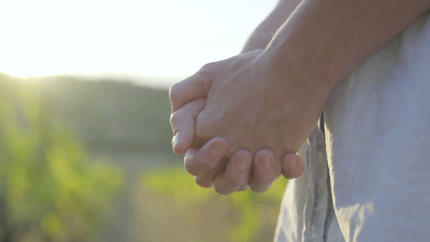 A person is holding their hands outdoors