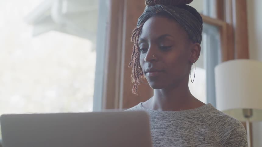 A woman sitting down looking at a laptop