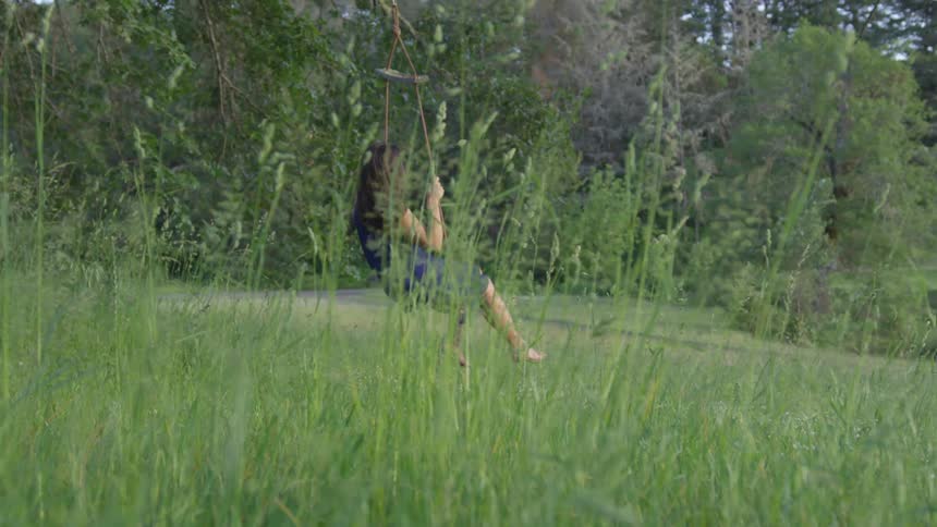 Woman swings on makeshift swing in the forest
