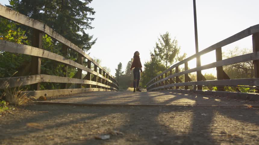Girl spinning around on a bridge
