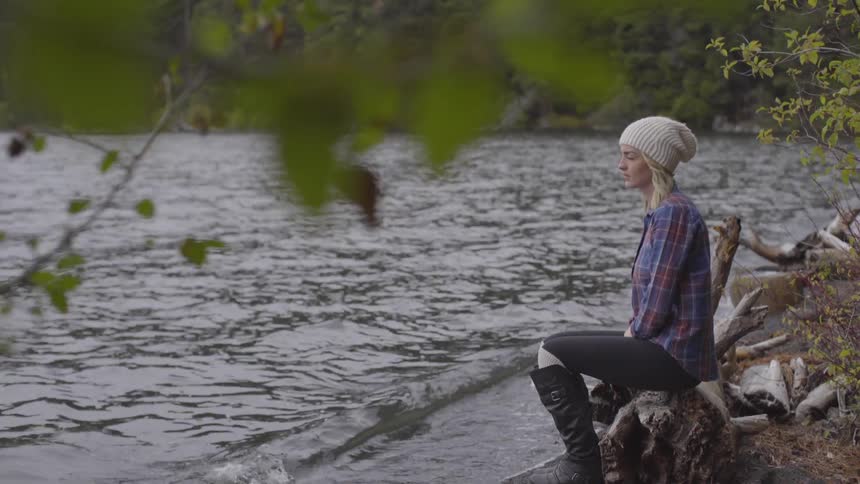 Girl sitting next to river