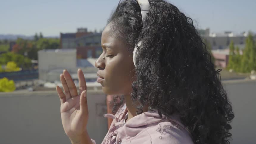 A young woman is listening to music on headphones