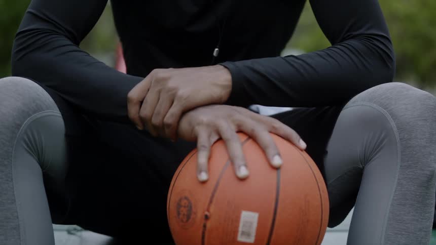 A man sitting holding a basketball