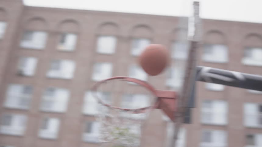 A man dribbles and makes a basketball shot