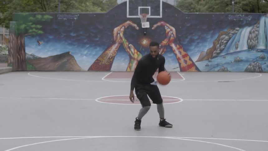 A young black man plays basketball
