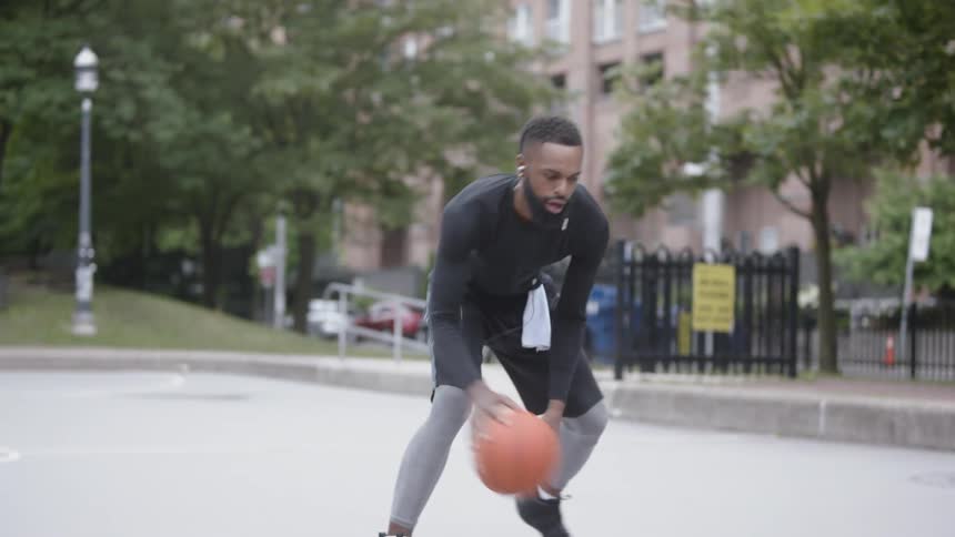 A man plays basketball outside